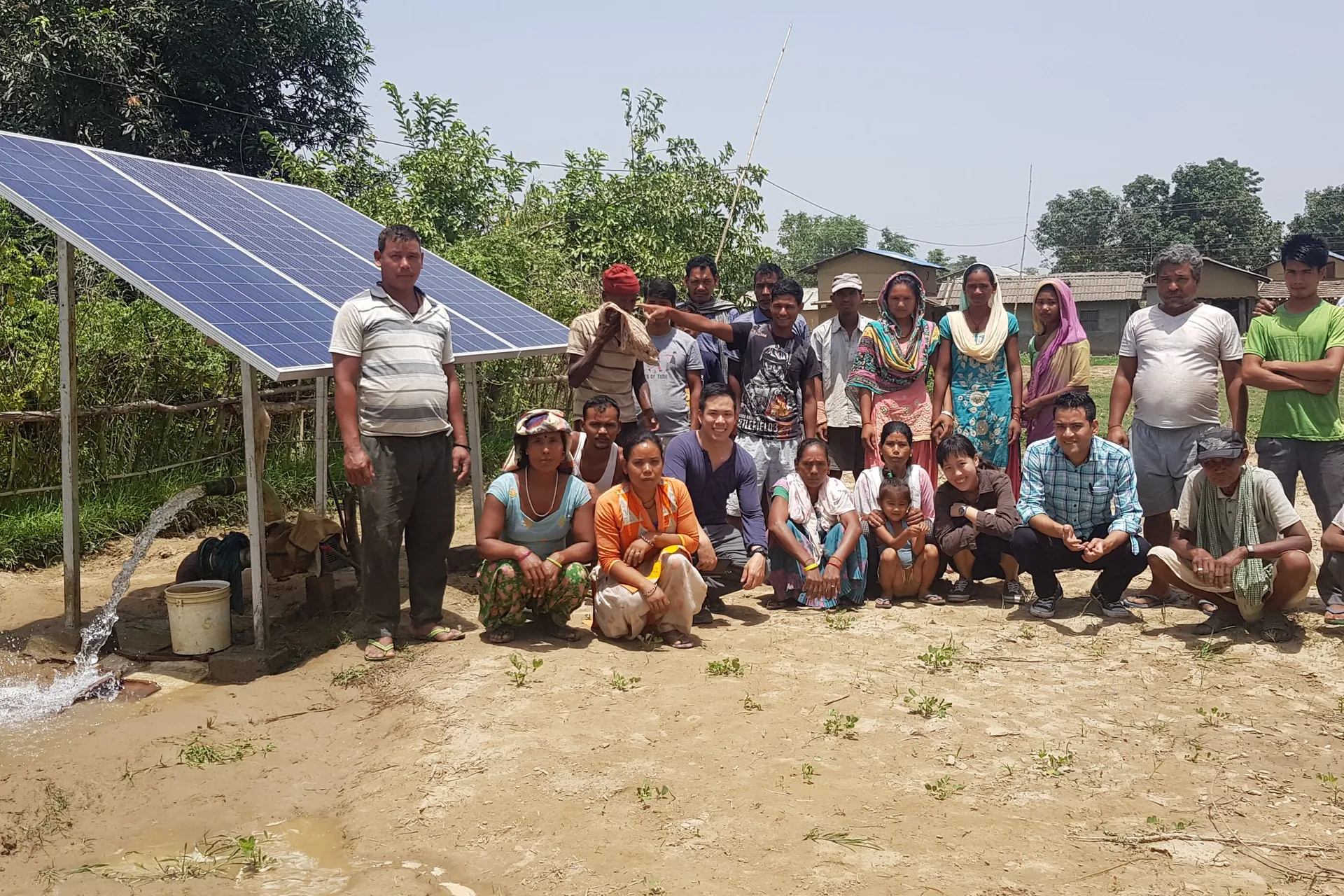 Farmers gathered around a community solar water pumping system